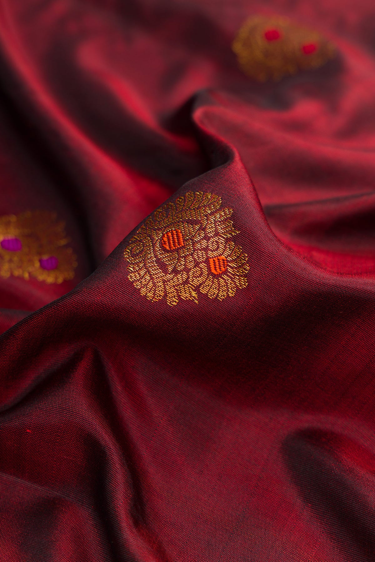 Close up of Maroon Dual Tone Gadwal Silk Saree with Zari Butta on the body and Zari And Thread Border.  displaying folds