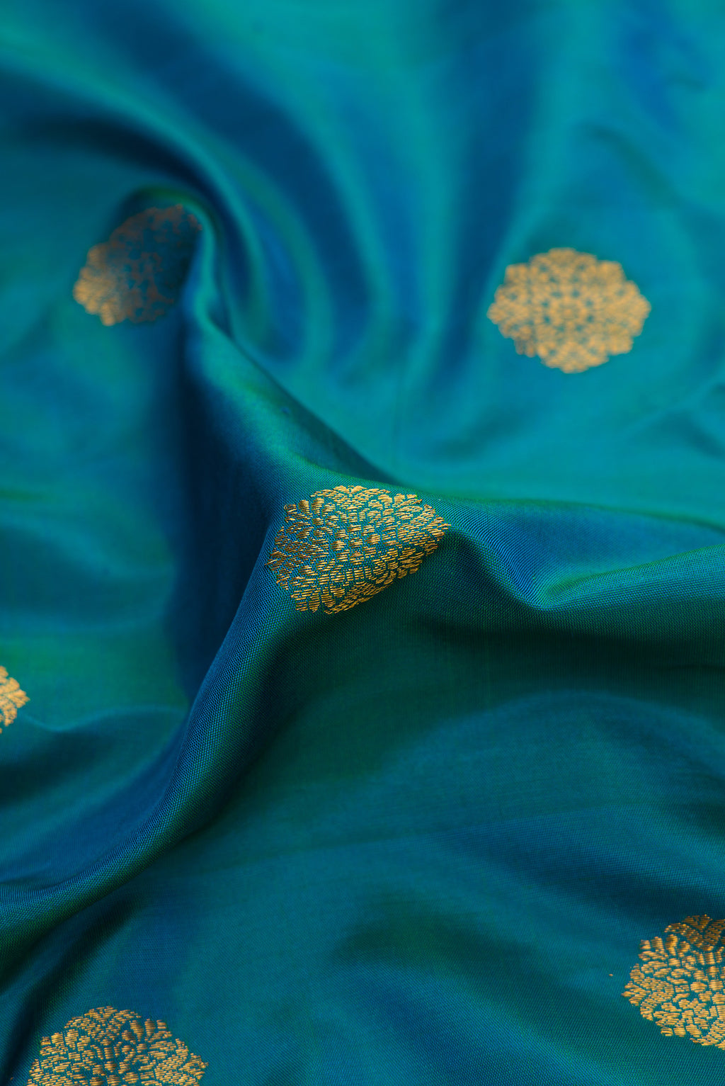 Close up of Peacock Blue Dual Tone Gadwal Silk Saree with Zari Butta on the body and Zari Border.  displaying folds