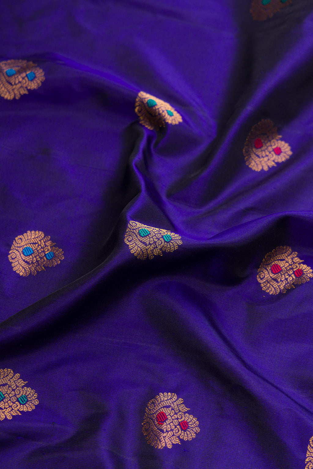 Close up of Royal Blue Dual Tone Gadwal Silk Saree with Zari And Thread Butta on the body and Zari Border.  displaying folds