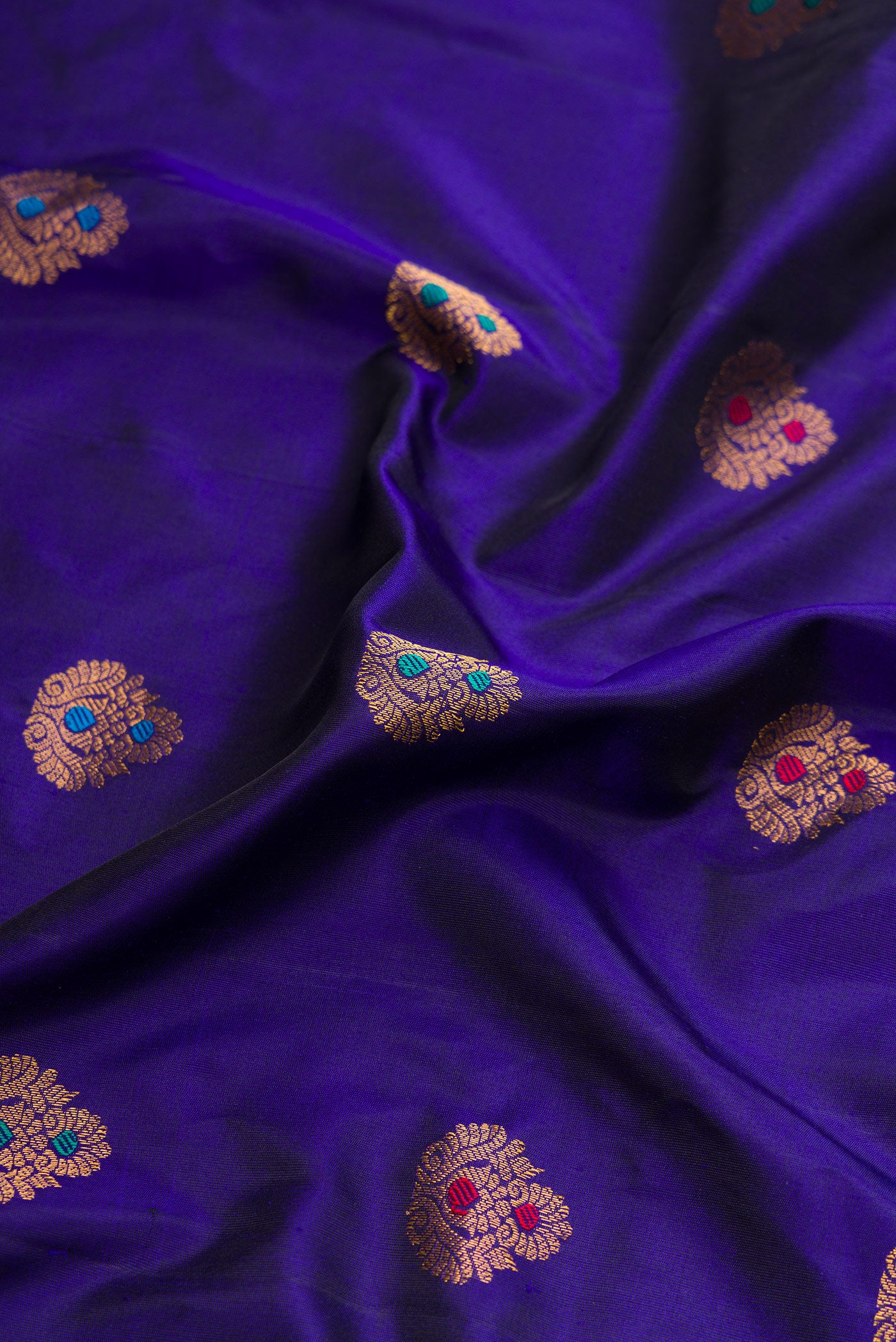 Close up of Royal Blue Dual Tone Gadwal Silk Saree with Zari And Thread Butta on the body and Zari Border.  displaying folds
