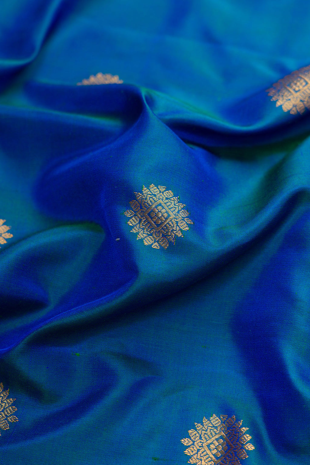 Close up of Peacock Blue Dual Tone Gadwal Silk Saree with Zari Butta on the body and Zari Border.  displaying folds
