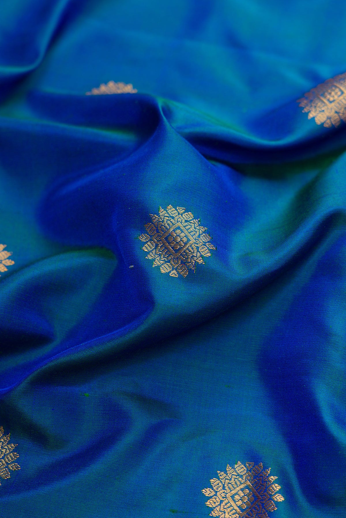 Close up of Peacock Blue Dual Tone Gadwal Silk Saree with Zari Butta on the body and Zari Border.  displaying folds