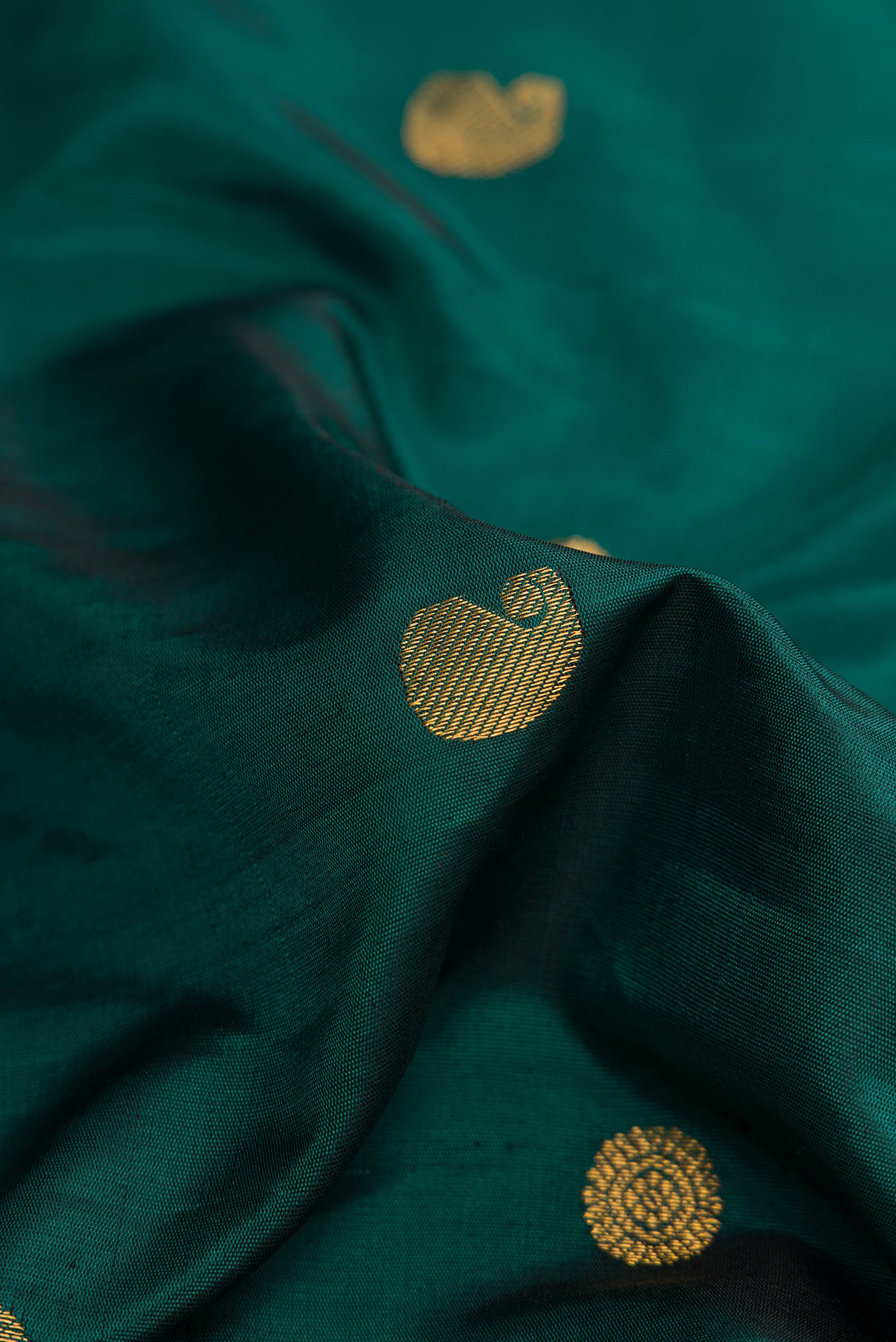 Close up of Green Dual Tone Gadwal Silk Saree with Zari Butta on the body and Paithani Border.  displaying folds