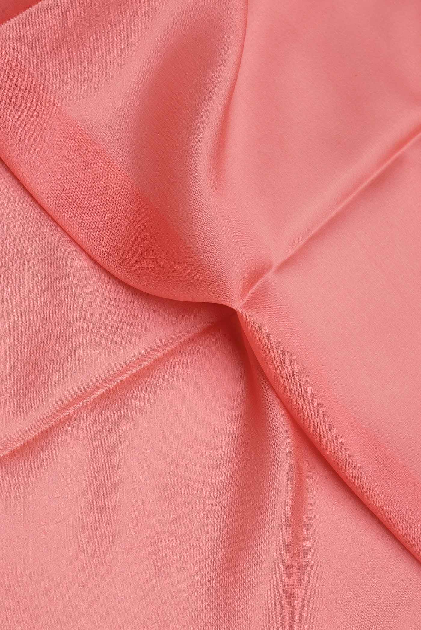 Close up of Peach Mysore Crepe Saree with Plain Body and Zari Border.  displaying folds