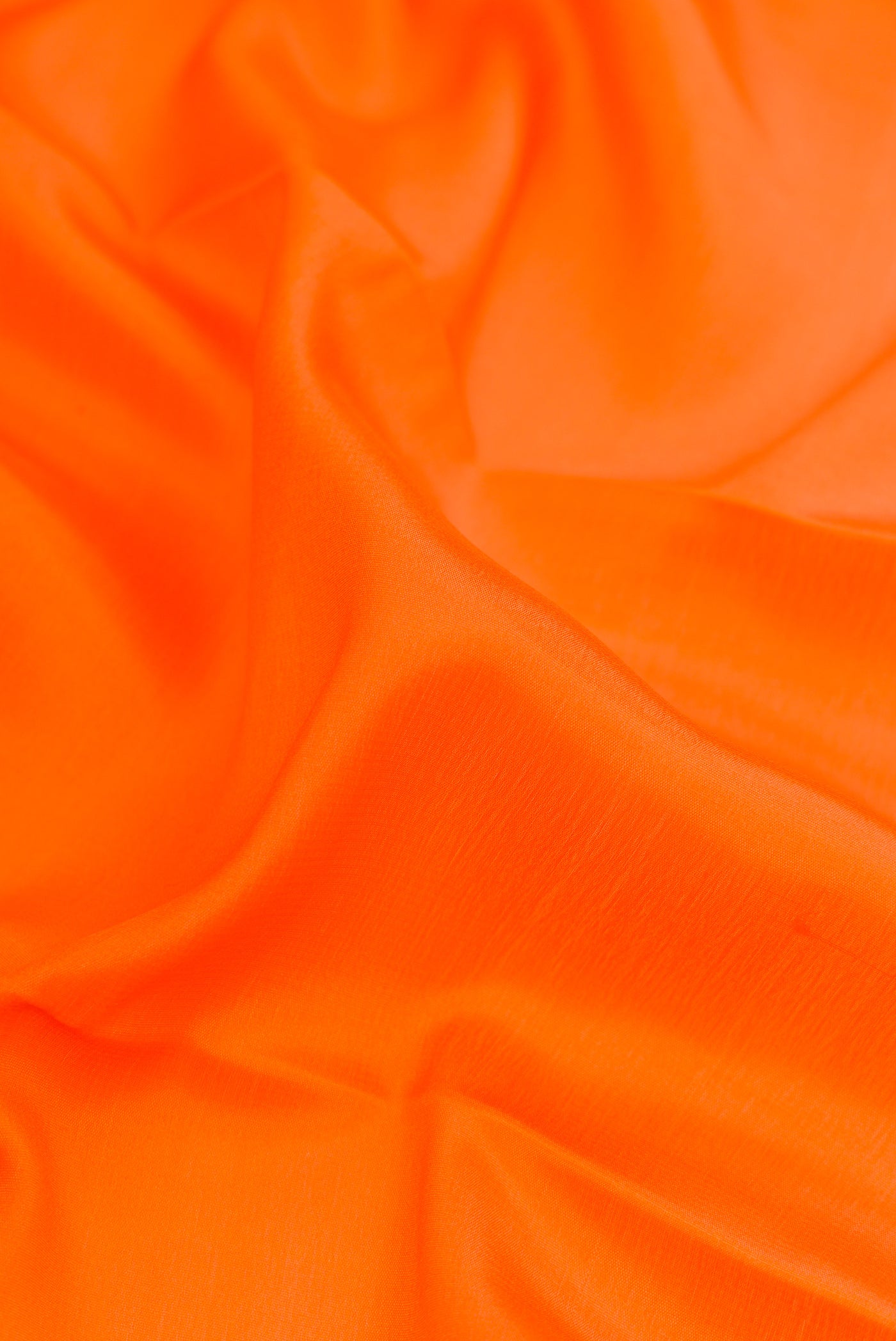 Close up of Orange Mysore Crepe Saree with Plain Body and Zari Border.  displaying folds
