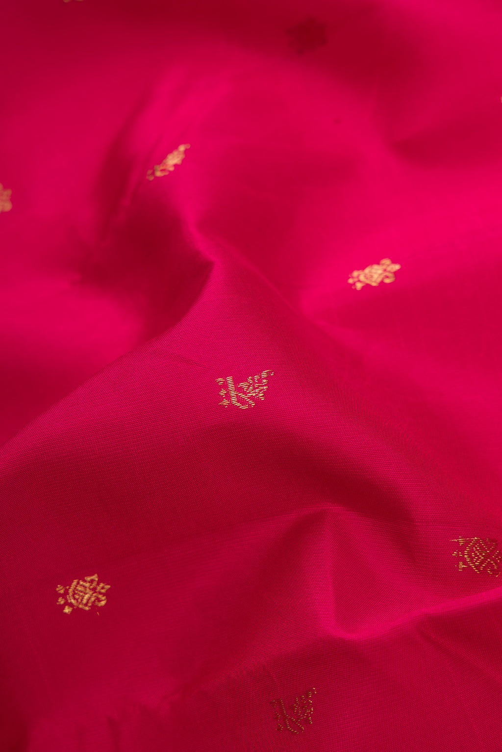 Close up of Maroon Dual Tone Kanchipuram Silk Saree with Zari Butta on the body and Temple Border.  displaying folds