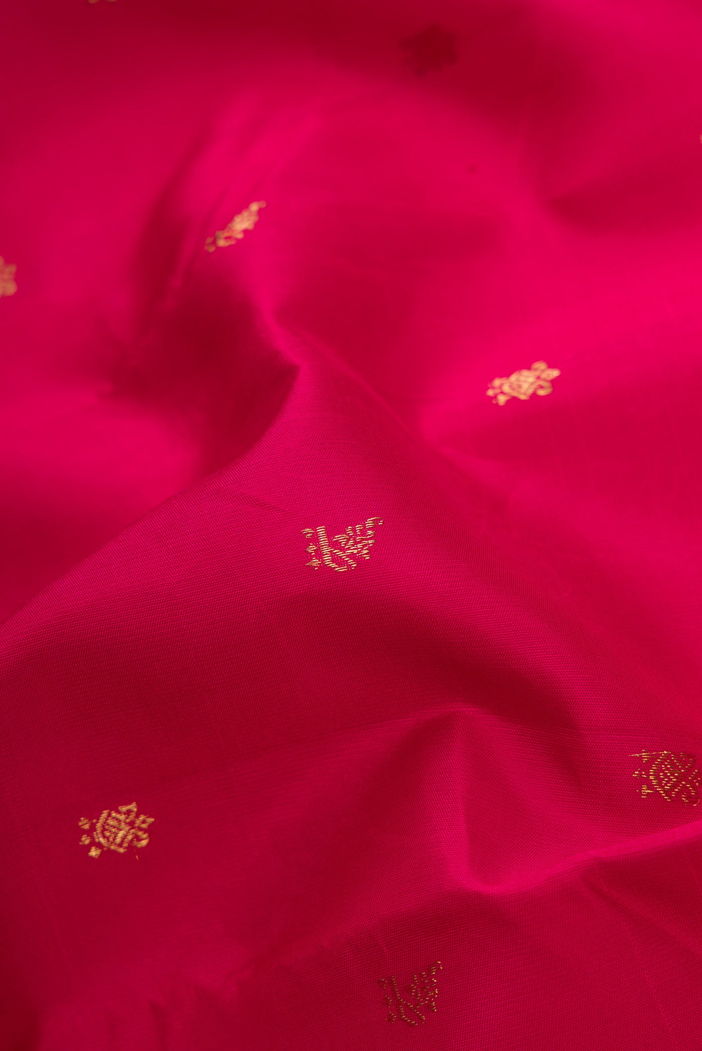 Close up of Maroon Dual Tone Kanchipuram Silk Saree with Zari Butta on the body and Temple Border.  displaying folds