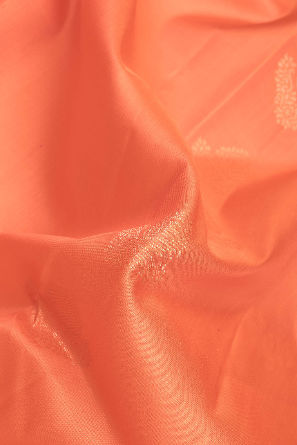 Close up of Golden Peach Dual Tone Soft Silk Saree with Zari Butta on the body and Fancy Border.  displaying folds