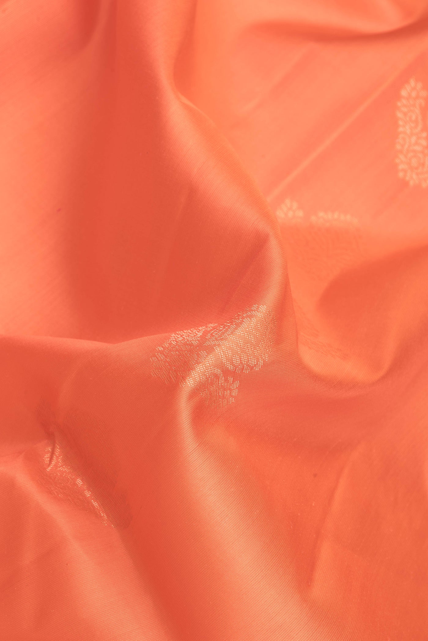 Close up of Golden Peach Dual Tone Soft Silk Saree with Zari Butta on the body and Fancy Border.  displaying folds