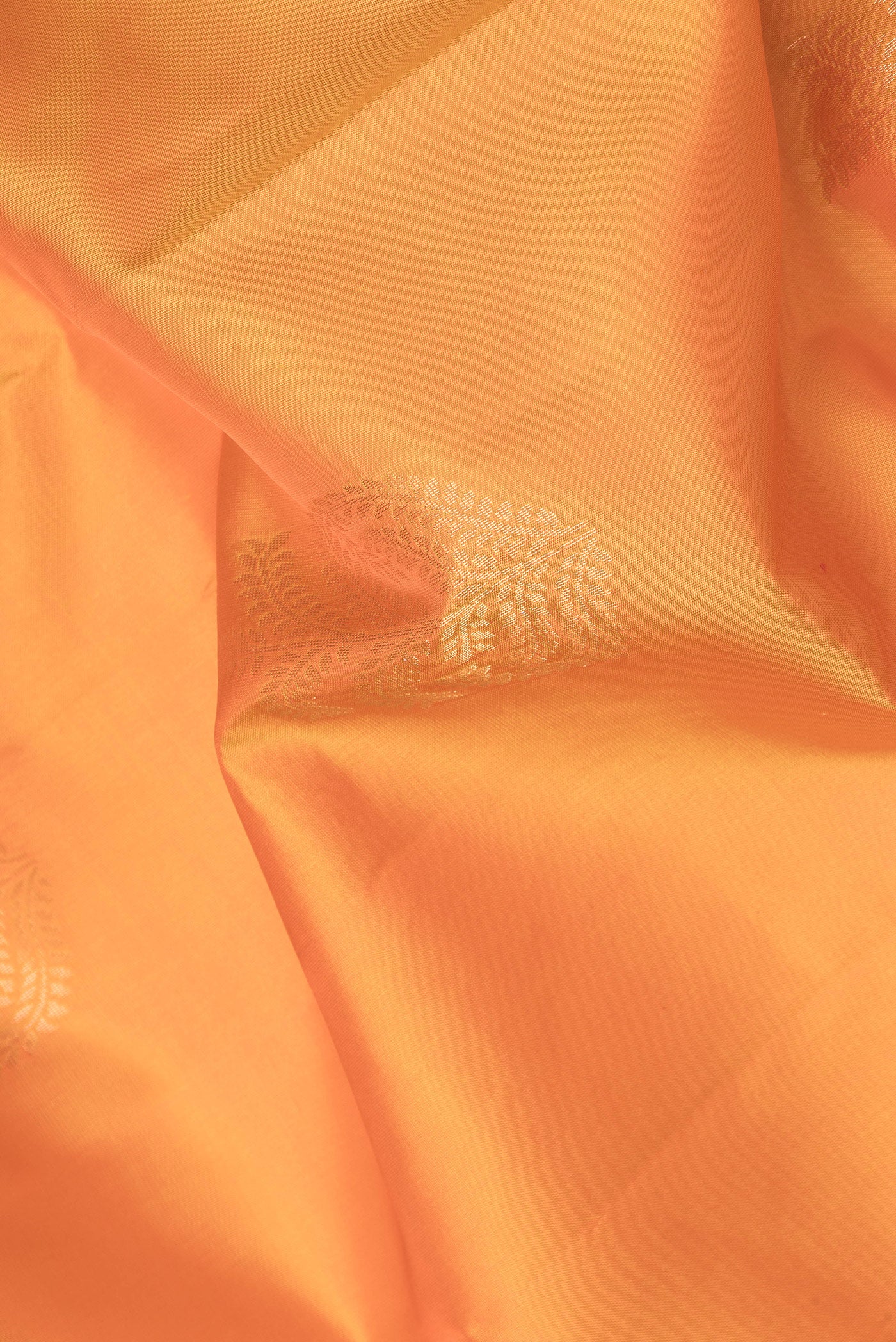 Close up of Orange Dual Tone Soft Silk Saree with Zari Butta on the body and Zari Border.  displaying folds