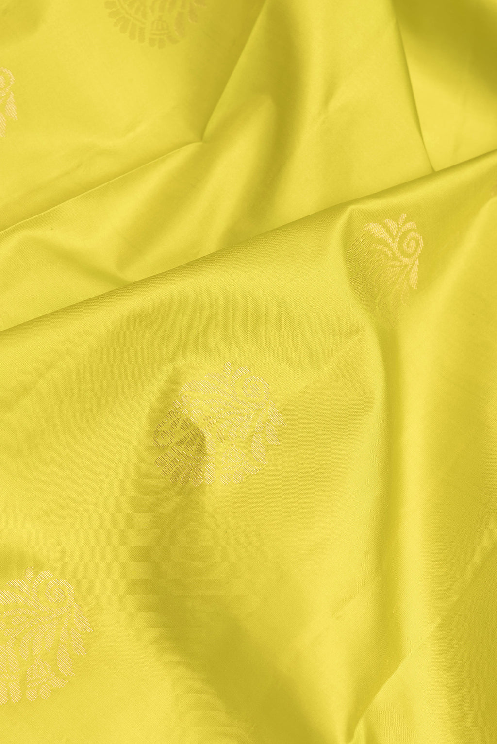 Close up of Parrot Green Dual Tone Soft Silk Saree with Zari Butta on the body and Fancy Border.  displaying folds