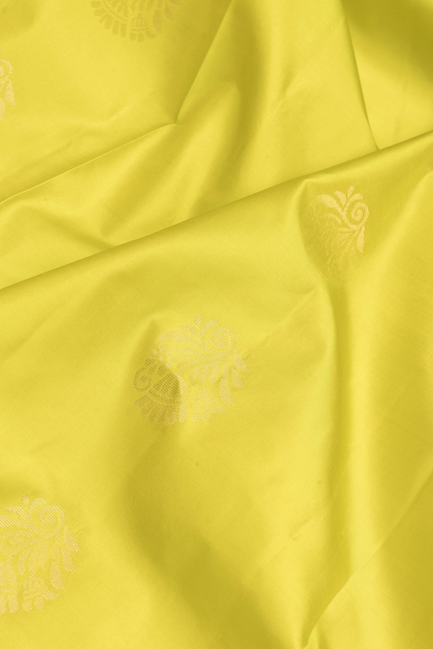Close up of Parrot Green Dual Tone Soft Silk Saree with Zari Butta on the body and Fancy Border.  displaying folds