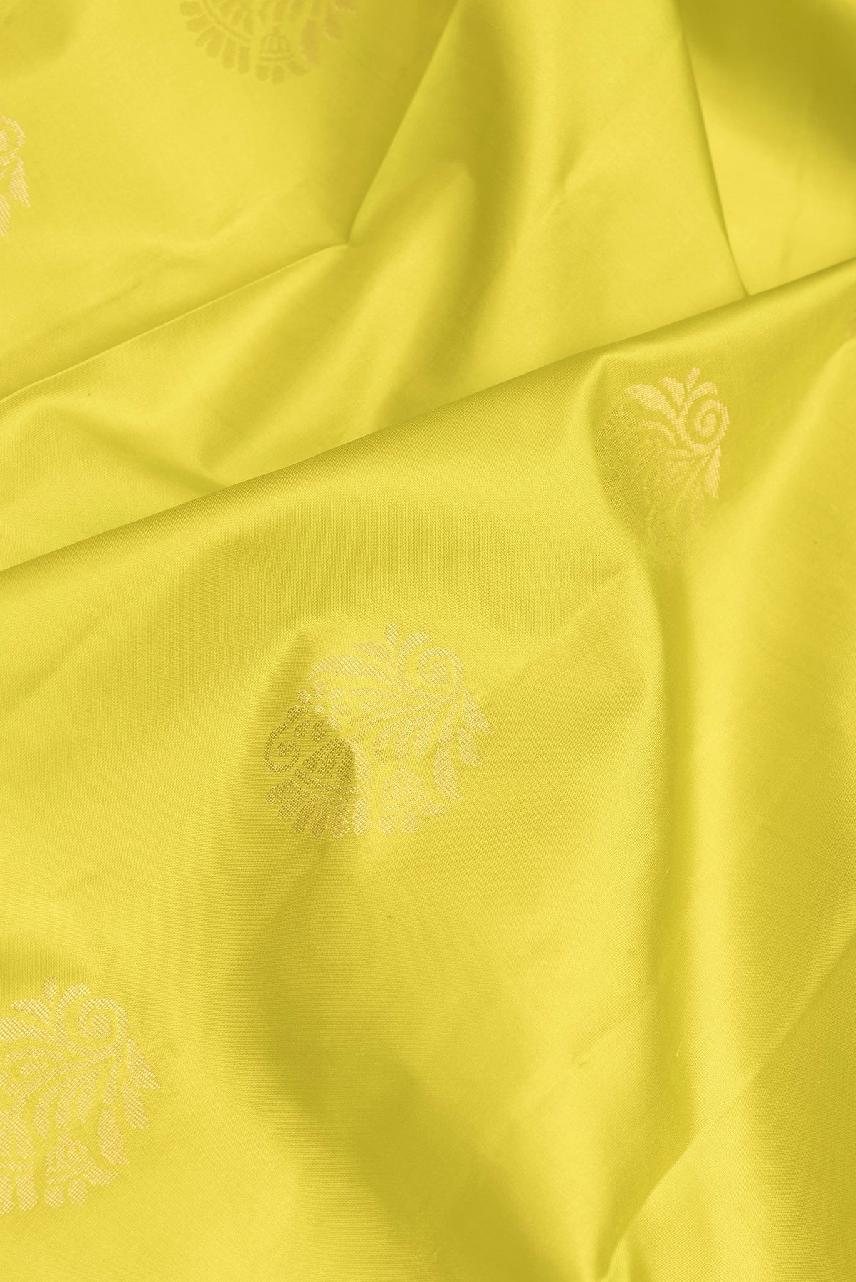 Close up of Parrot Green Dual Tone Soft Silk Saree with Zari Butta on the body and Fancy Border.  displaying folds