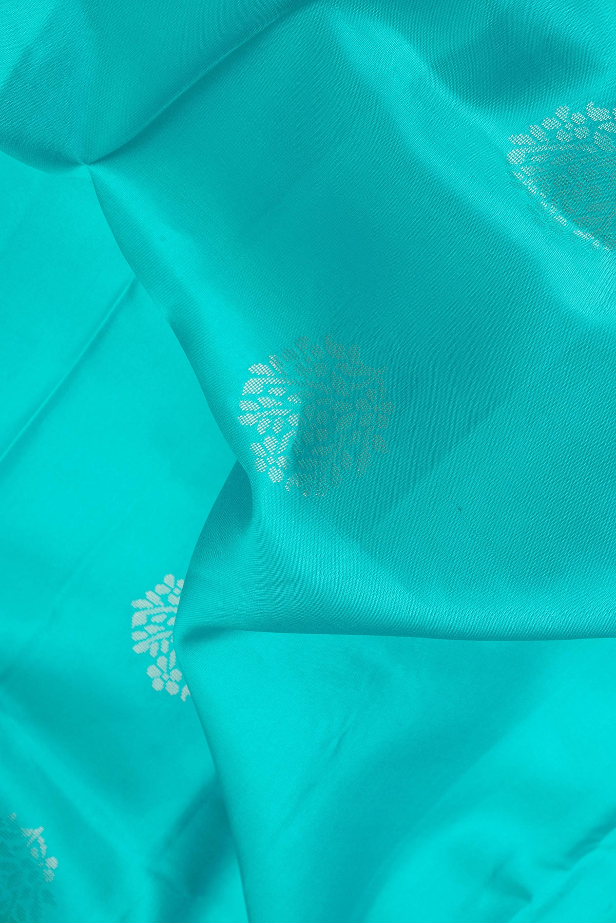 Close up of Sky Blue Dual Tone Soft Silk Saree with Zari Butta on the body and Fancy Border.  displaying folds