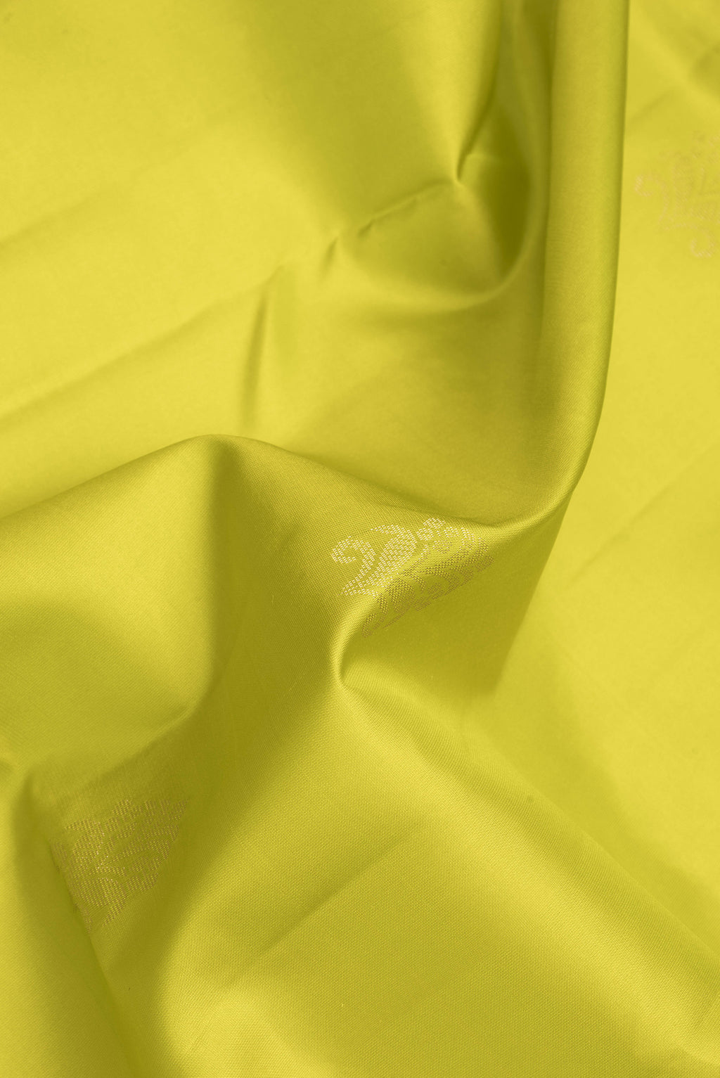 Close up of Parrot Green Dual Tone Soft Silk Saree with Zari Butta on the body and Fancy Border.  displaying folds