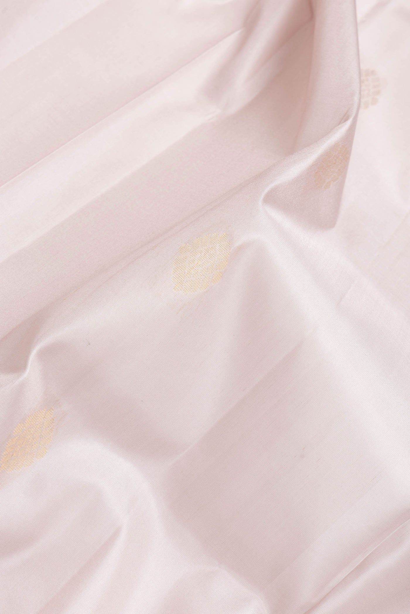 Close up of Rose Gold Dual Tone Soft Silk Saree with Zari Butta on the body and Fancy Border.  displaying folds