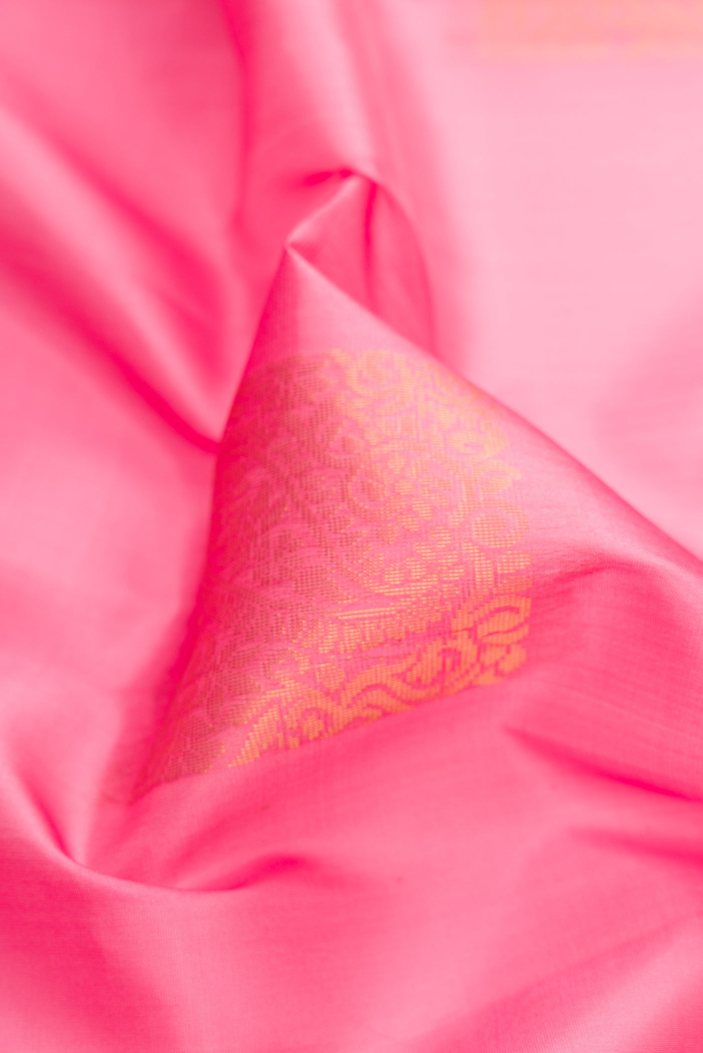 Close up of Pink Soft Silk Saree with Zari Butta on the body and Zari Border.  displaying folds