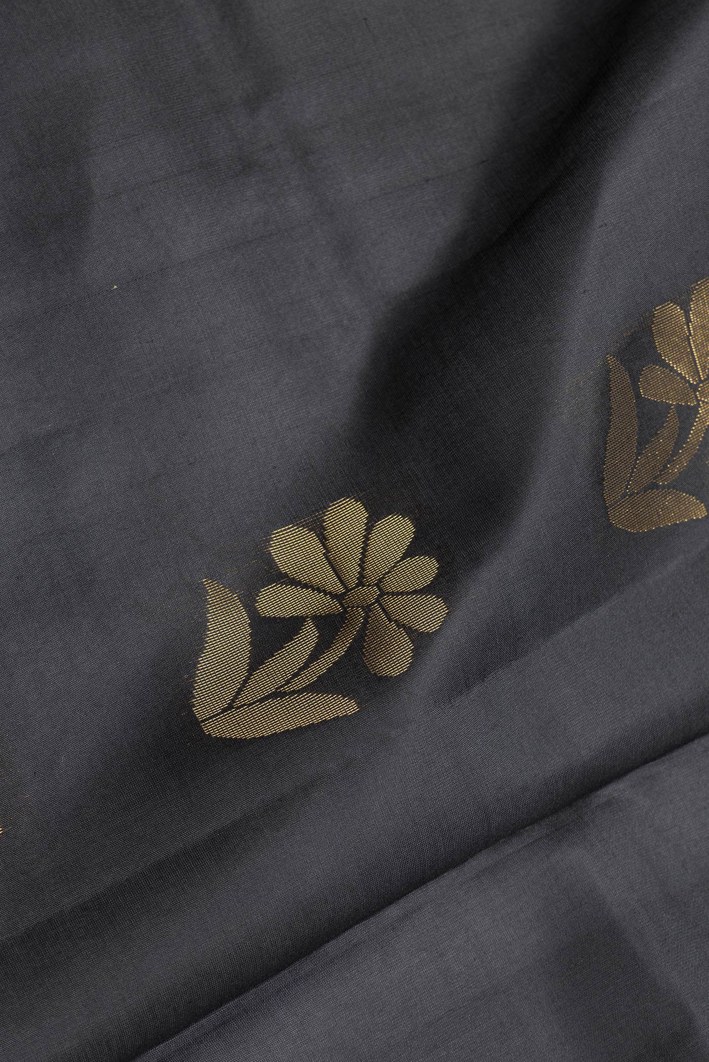 Close up of Black Dual Tone Soft Silk Saree with Zari Butta on the body and Fancy Border.  displaying folds