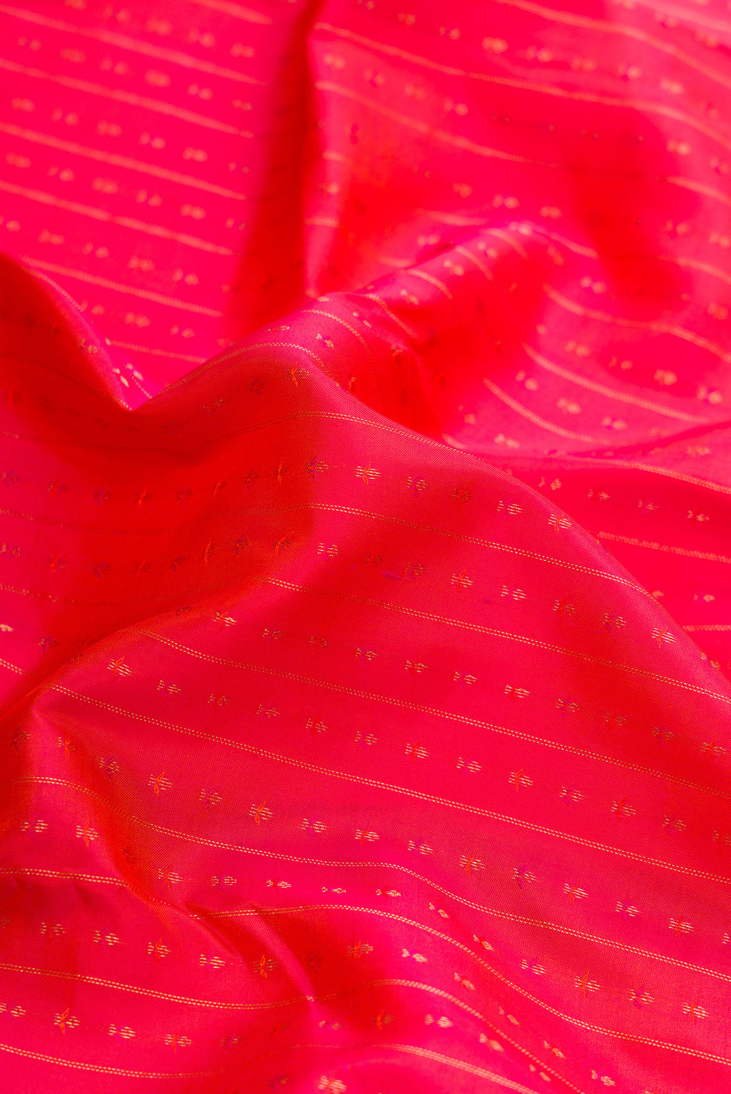 Close up of Orange Dual Tone Kanchipuram Silk Saree with Zari Butta on the body and Zari Border.  displaying folds