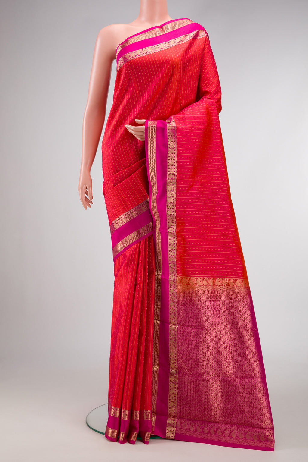 Orange Dual Tone Kanchipuram Silk Saree with Zari Butta on the body and Zari Border.  displayed on a mannequin
