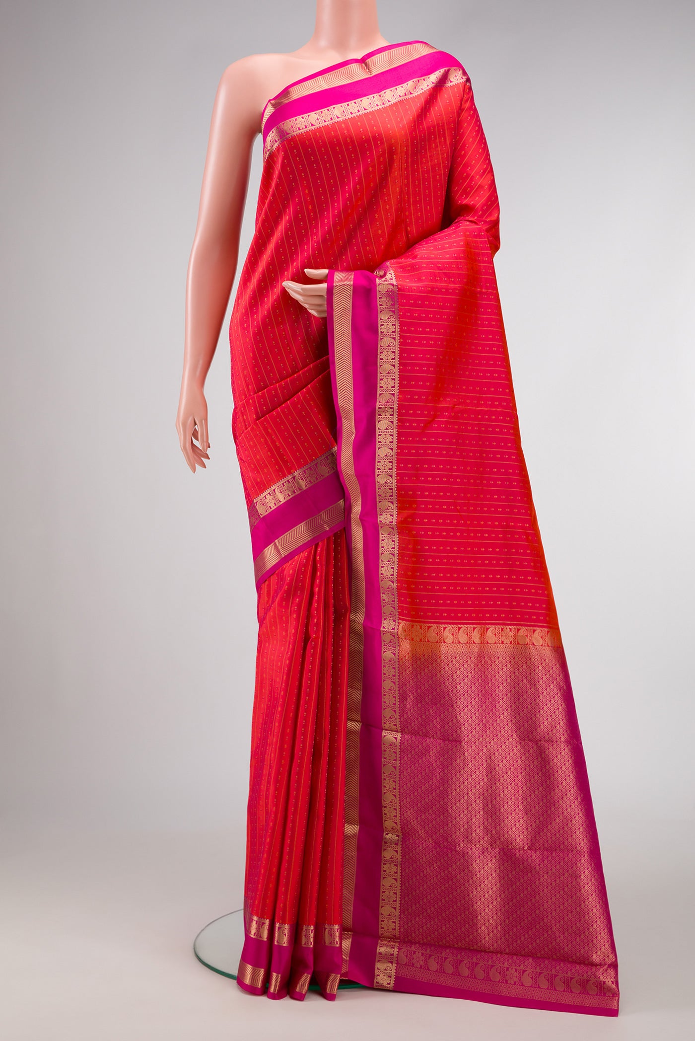 Orange Dual Tone Kanchipuram Silk Saree with Zari Butta on the body and Zari Border.  displayed on a mannequin