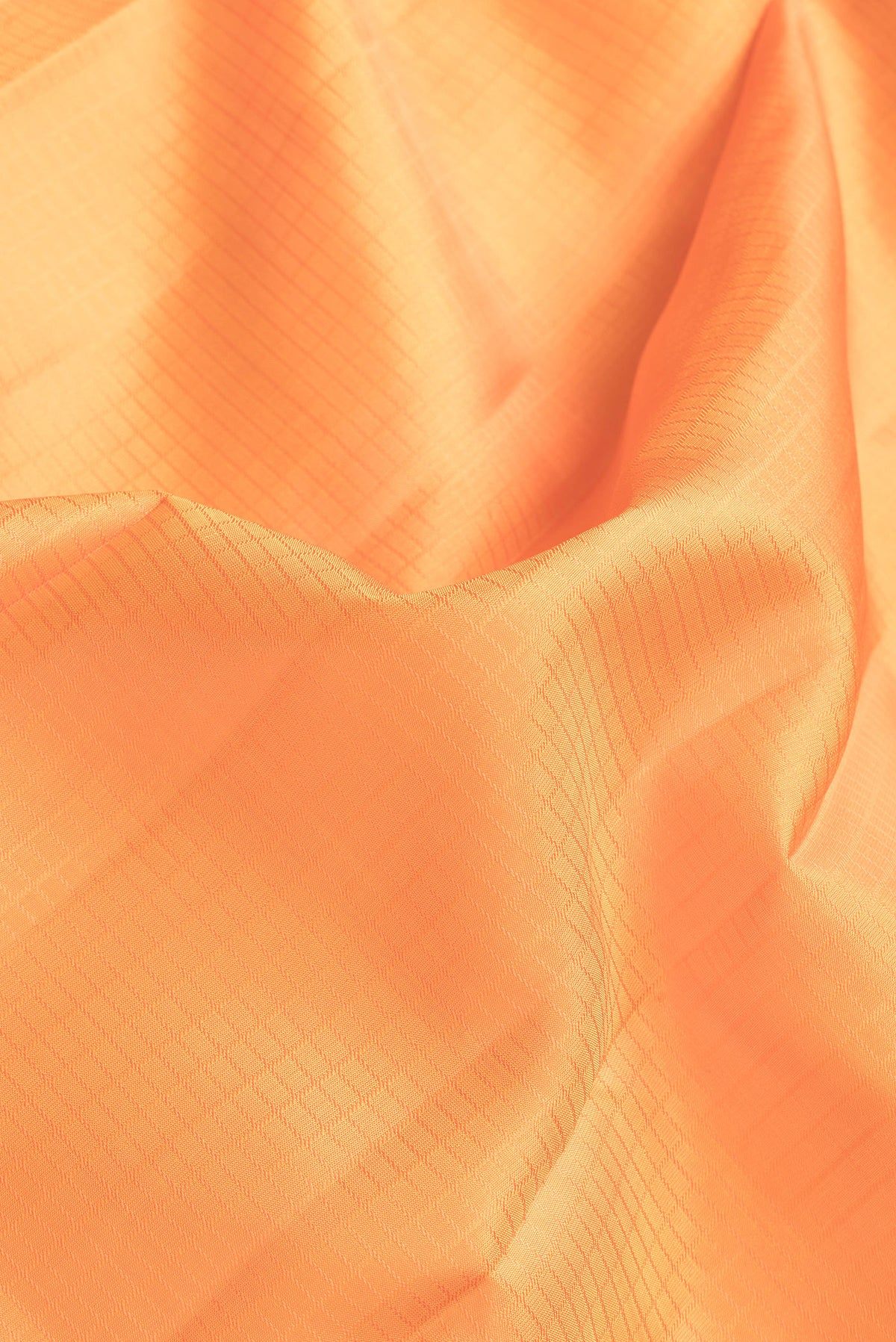 Close up of Orange Dual Tone Kanchipuram Silk Saree with Checked design on the body and Zari Border.  displaying folds