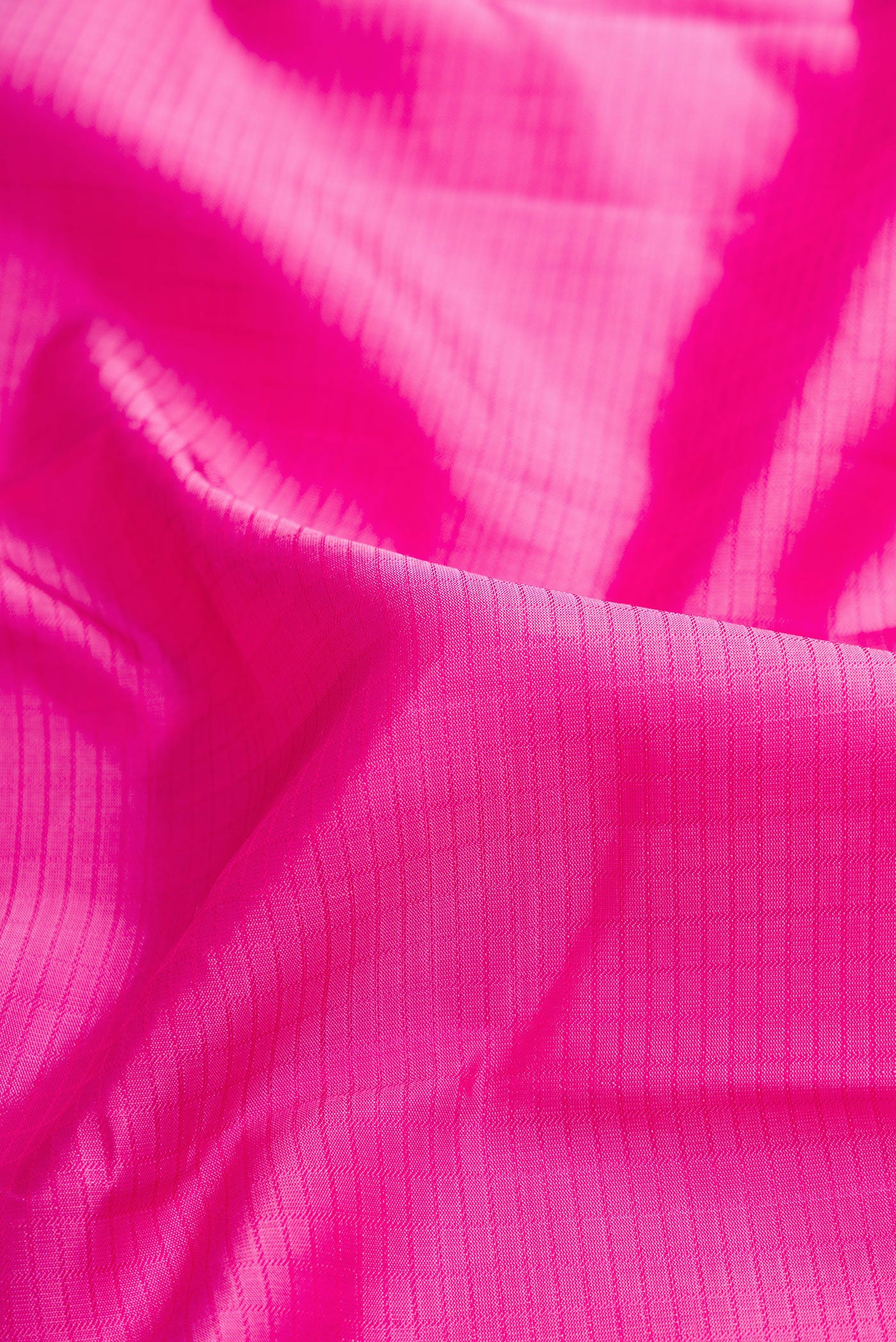 Close up of Pink Dual Tone Kanchipuram Silk Saree with Zari Butta on the body and Zari Border.  displaying folds