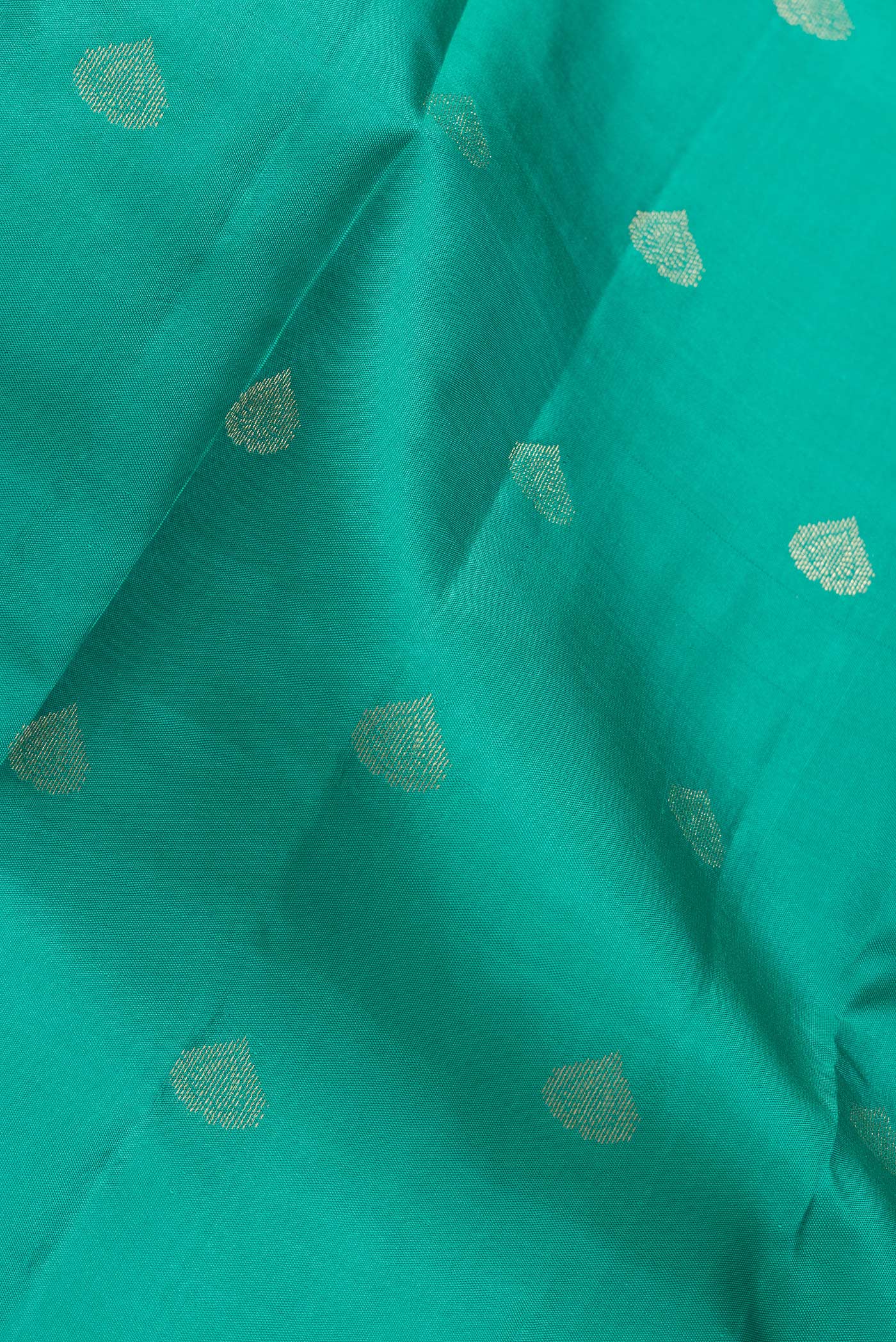 Close up of Green Dual Tone Kanchipuram Silk Saree with Zari Butta on the body and Zari Border.  displaying folds