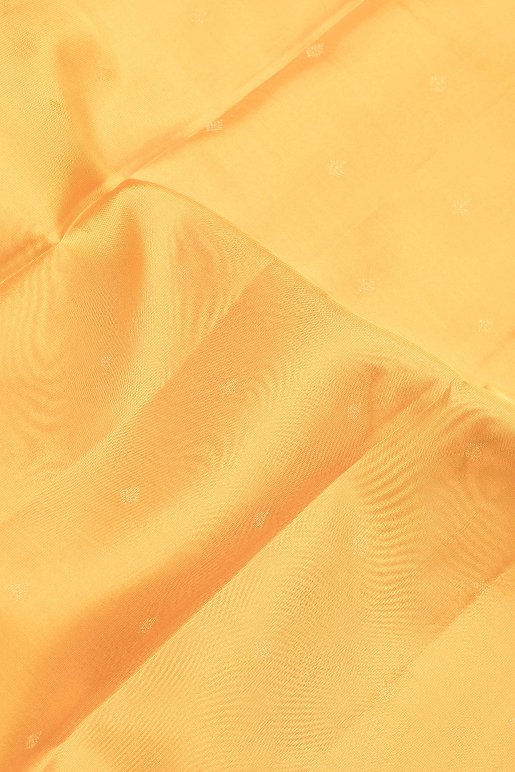 Close up of Yellow Dual Tone Kanchipuram Silk Saree with Zari Butta on the body and Zari Border.  displaying folds
