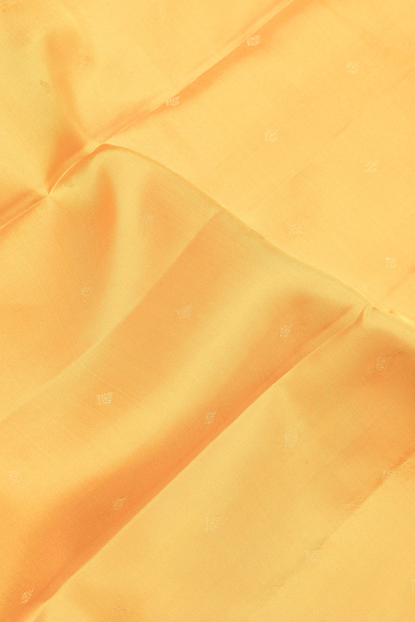 Close up of Yellow Dual Tone Kanchipuram Silk Saree with Zari Butta on the body and Zari Border.  displaying folds