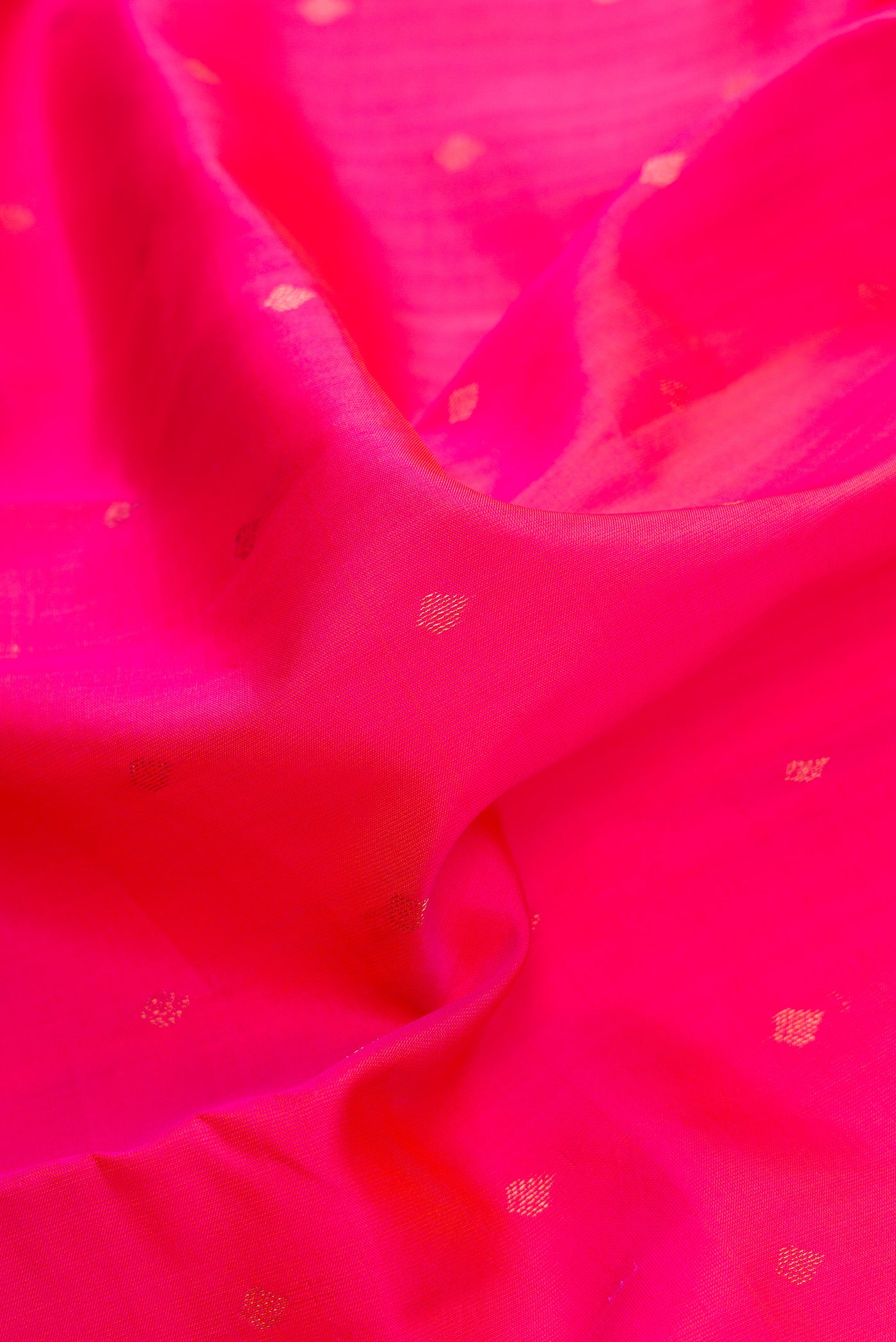 Close up of Rani Pink Dual Tone Kanchipuram Silk Saree with Zari Butta on the body and Zari Border.  displaying folds