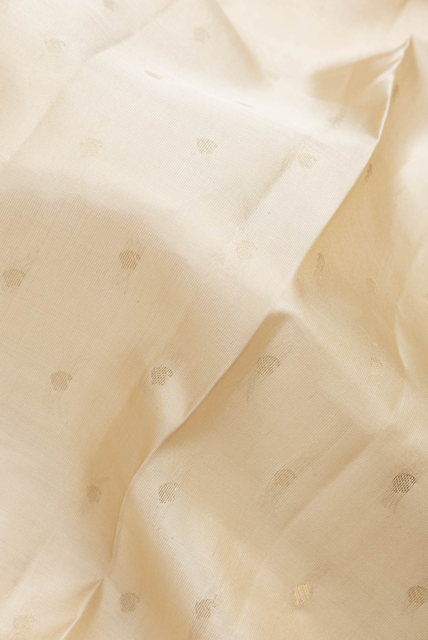 Close up of Beige Dual Tone Kanchipuram Silk Saree with Zari Butta on the body and Zari Border.  displaying folds