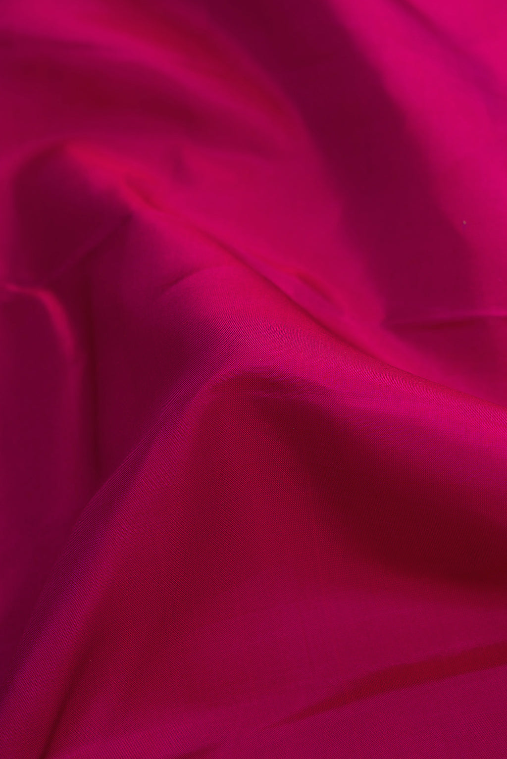 Close up of Magenta Dual Tone Kanchipuram Silk Saree with Plain Body and Thin Zari Line.  displaying folds