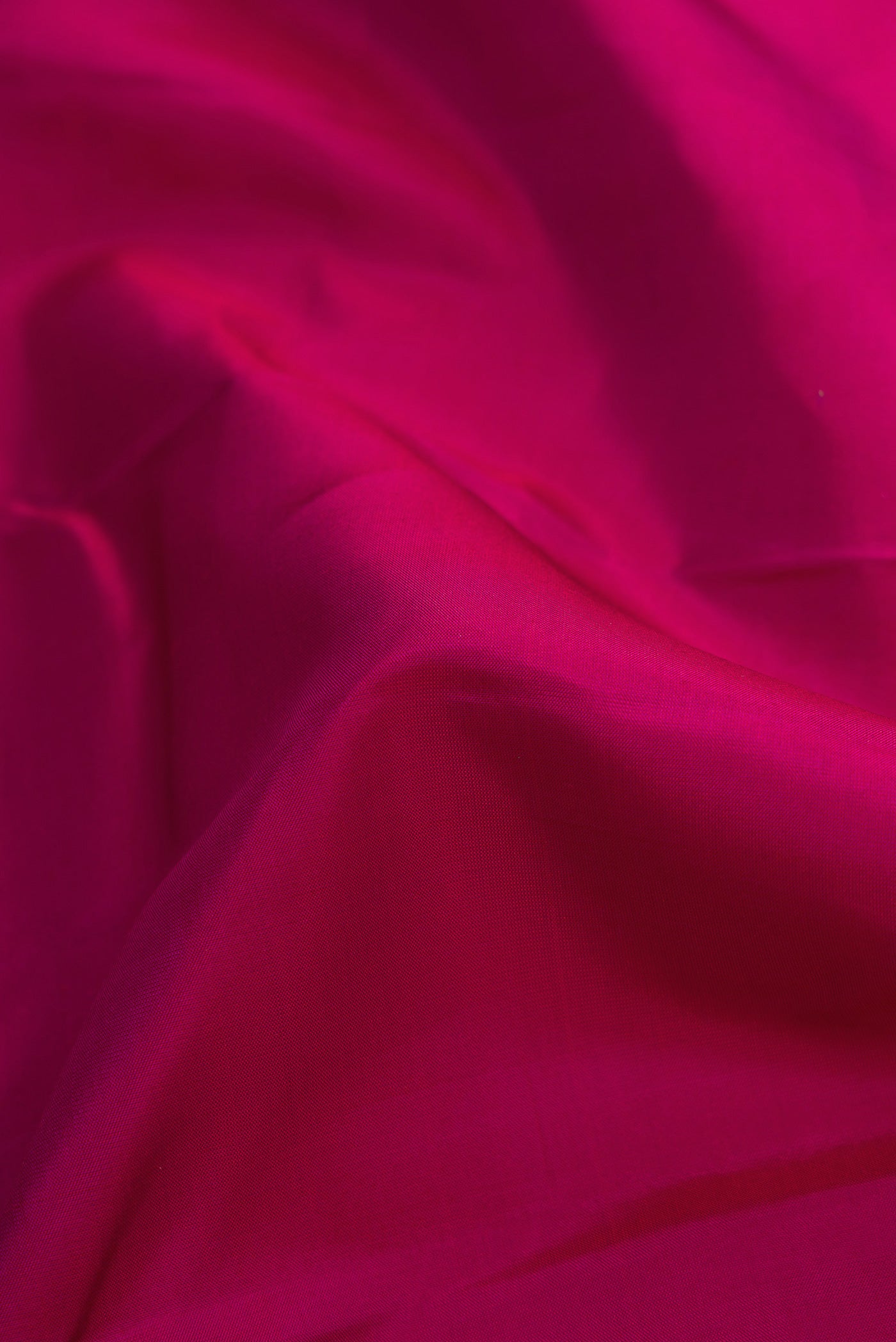 Close up of Magenta Dual Tone Kanchipuram Silk Saree with Plain Body and Thin Zari Line.  displaying folds