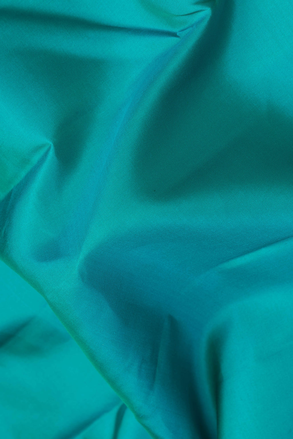 Close up of Peacock Blue Kanchipuram Silk Saree with Plain Body and Zari Border.  displaying folds