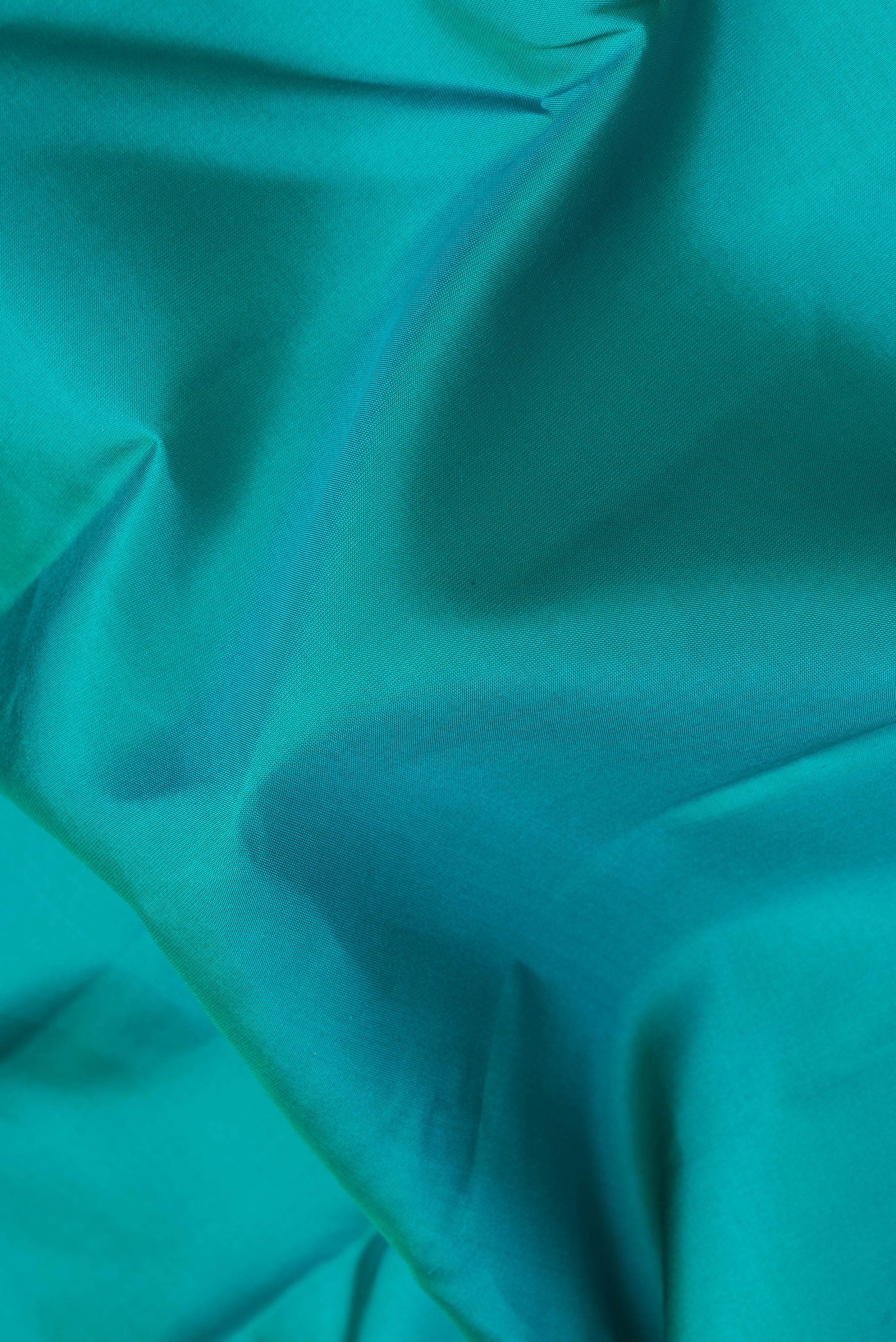 Close up of Peacock Blue Kanchipuram Silk Saree with Plain Body and Zari Border.  displaying folds