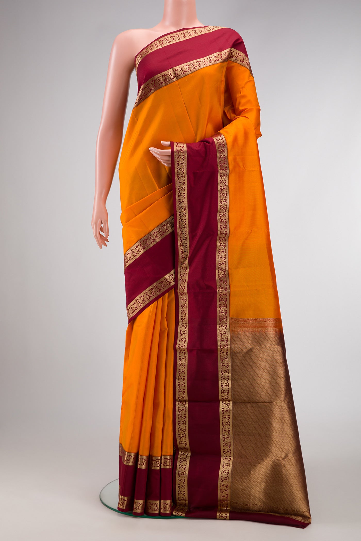Orange Dual Tone Kanchipuram Silk Saree with Plain Body and Zari Border.  displayed on a mannequin