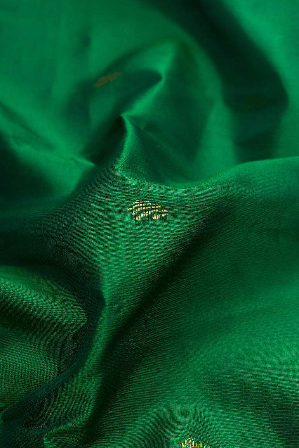 Close up of Green Dual Tone Kanchipuram Silk Saree with Zari Butta on the body and Zari Border.  displaying folds