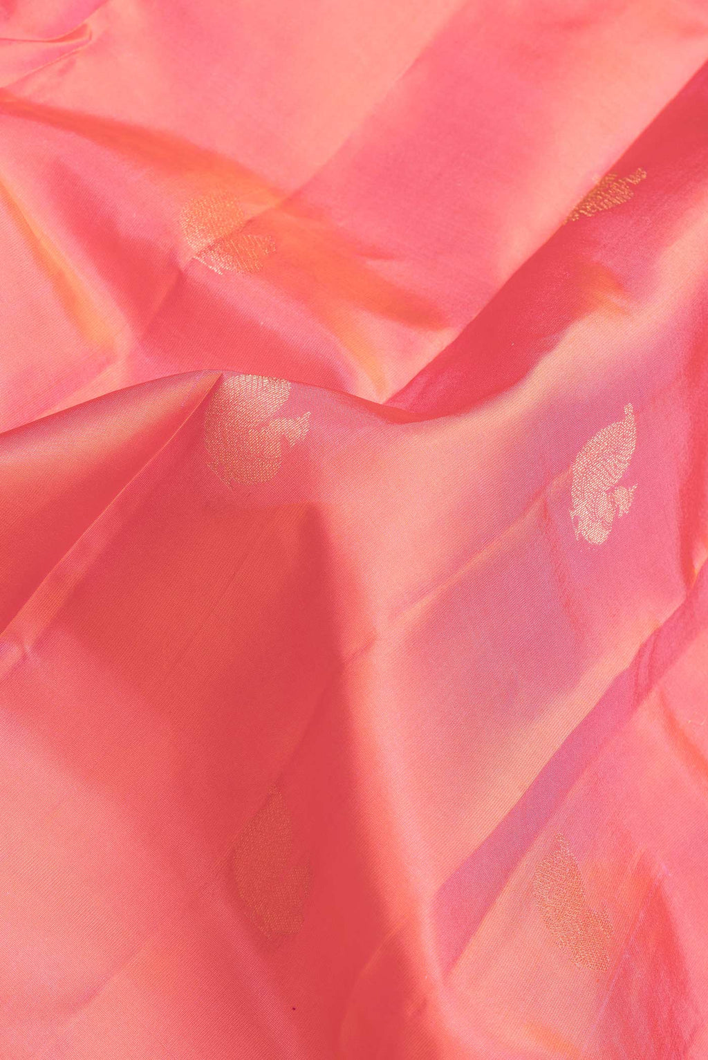 Close up of Coral Dual Tone Kanchipuram Silk Saree with Zari Butta on the body and Zari Border.  displaying folds