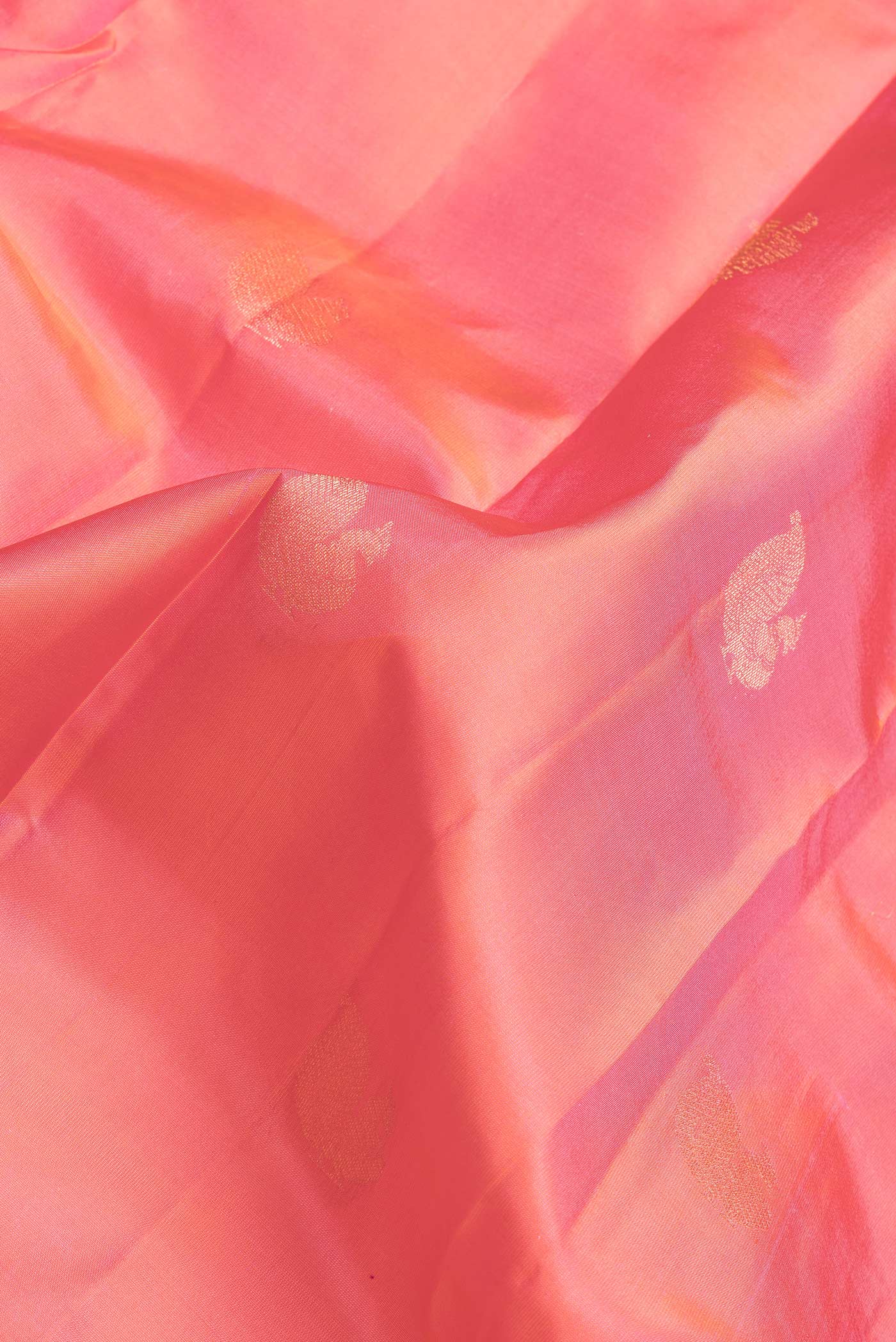 Close up of Coral Dual Tone Kanchipuram Silk Saree with Zari Butta on the body and Zari Border.  displaying folds
