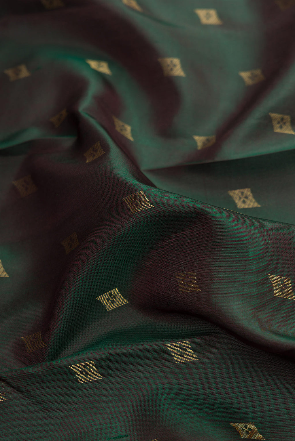 Close up of Bottle Green Dual Tone Kanchipuram Silk Saree with Zari Butta on the body and Zari Border.  displaying folds