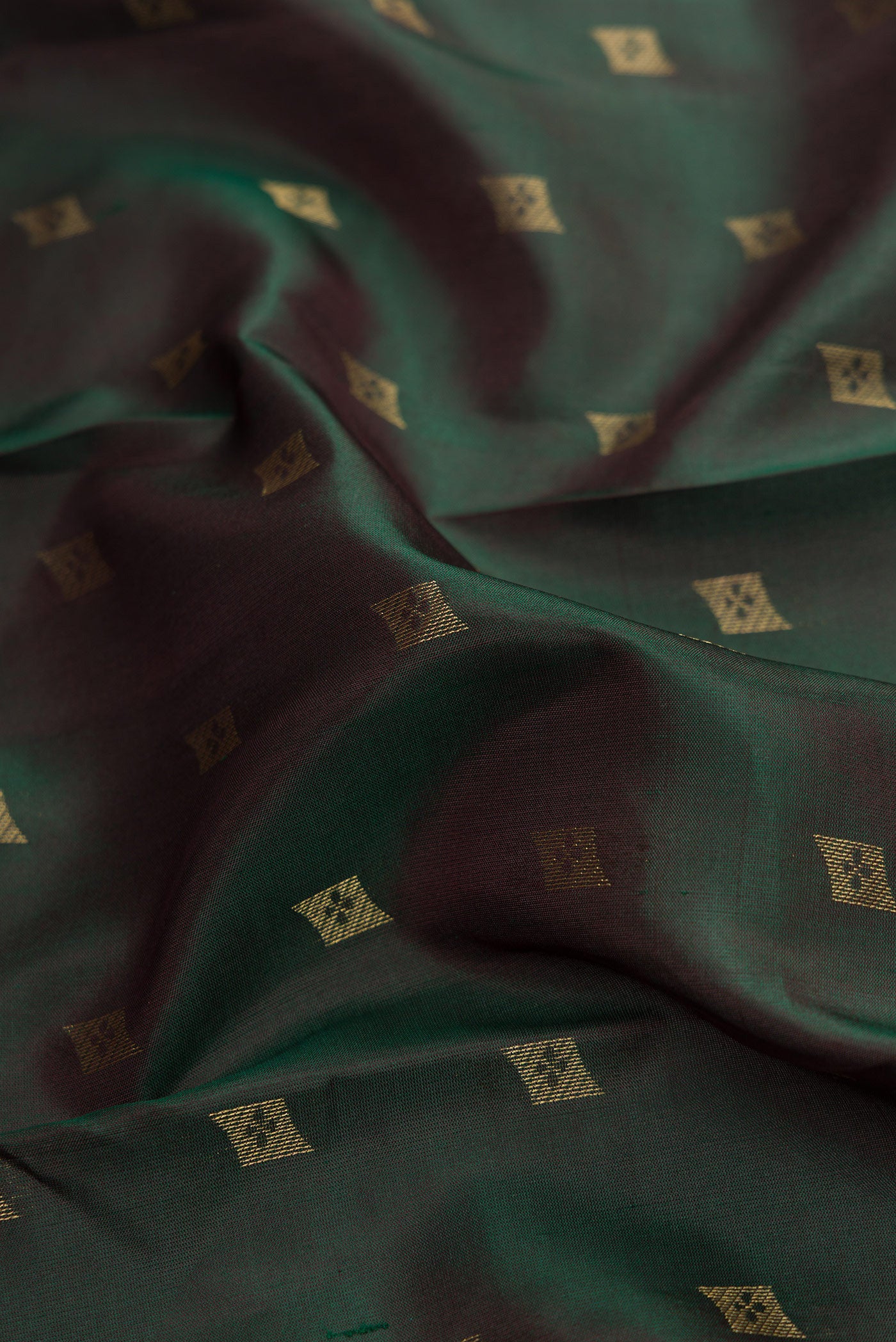 Close up of Bottle Green Dual Tone Kanchipuram Silk Saree with Zari Butta on the body and Zari Border.  displaying folds