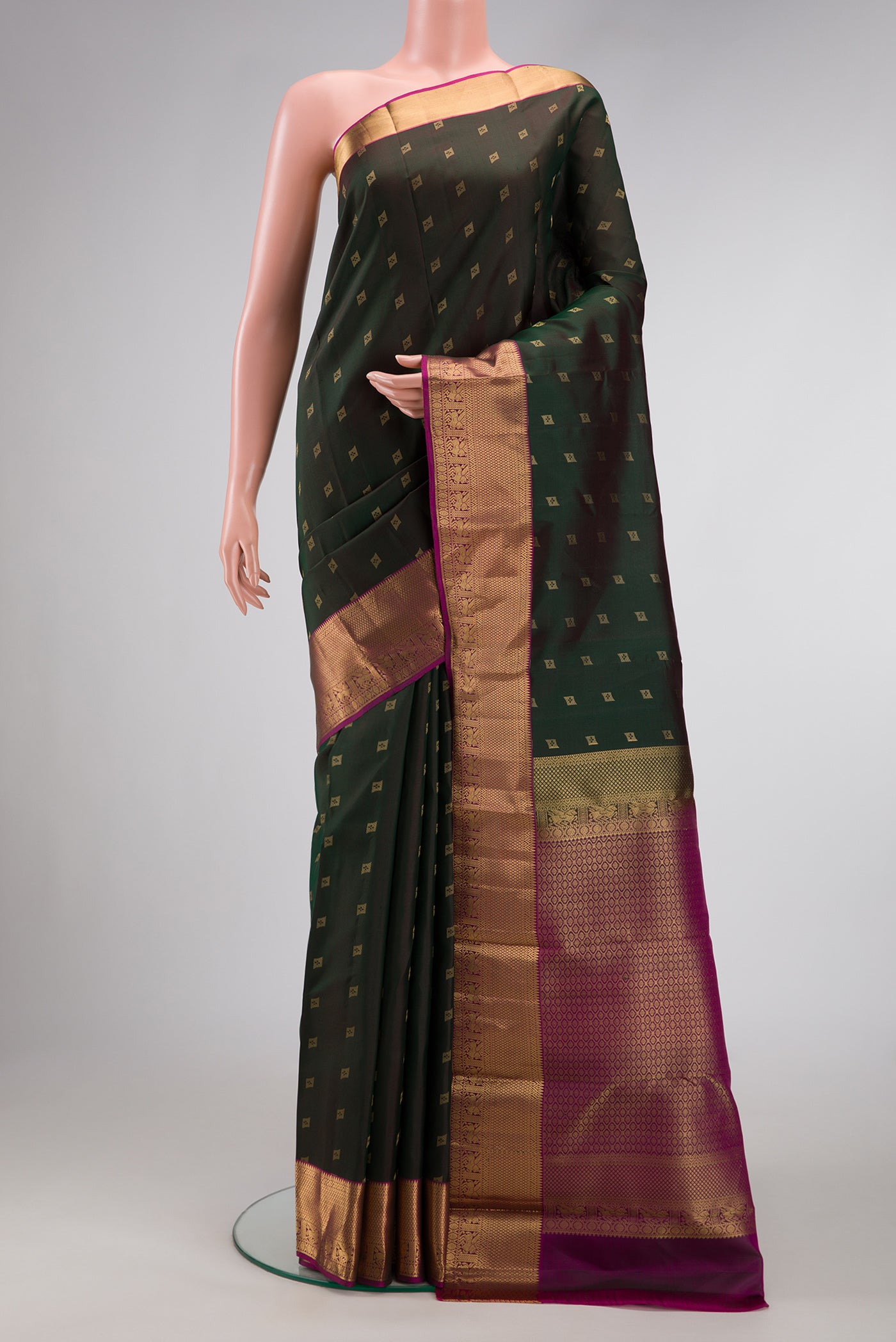 Bottle Green Dual Tone Kanchipuram Silk Saree with Zari Butta on the body and Zari Border.  displayed on a mannequin