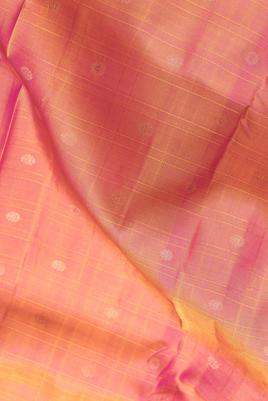 Close up of Coral Dual Tone Kanchipuram Silk Saree with Checked design on the body and Zari Border.  displaying folds