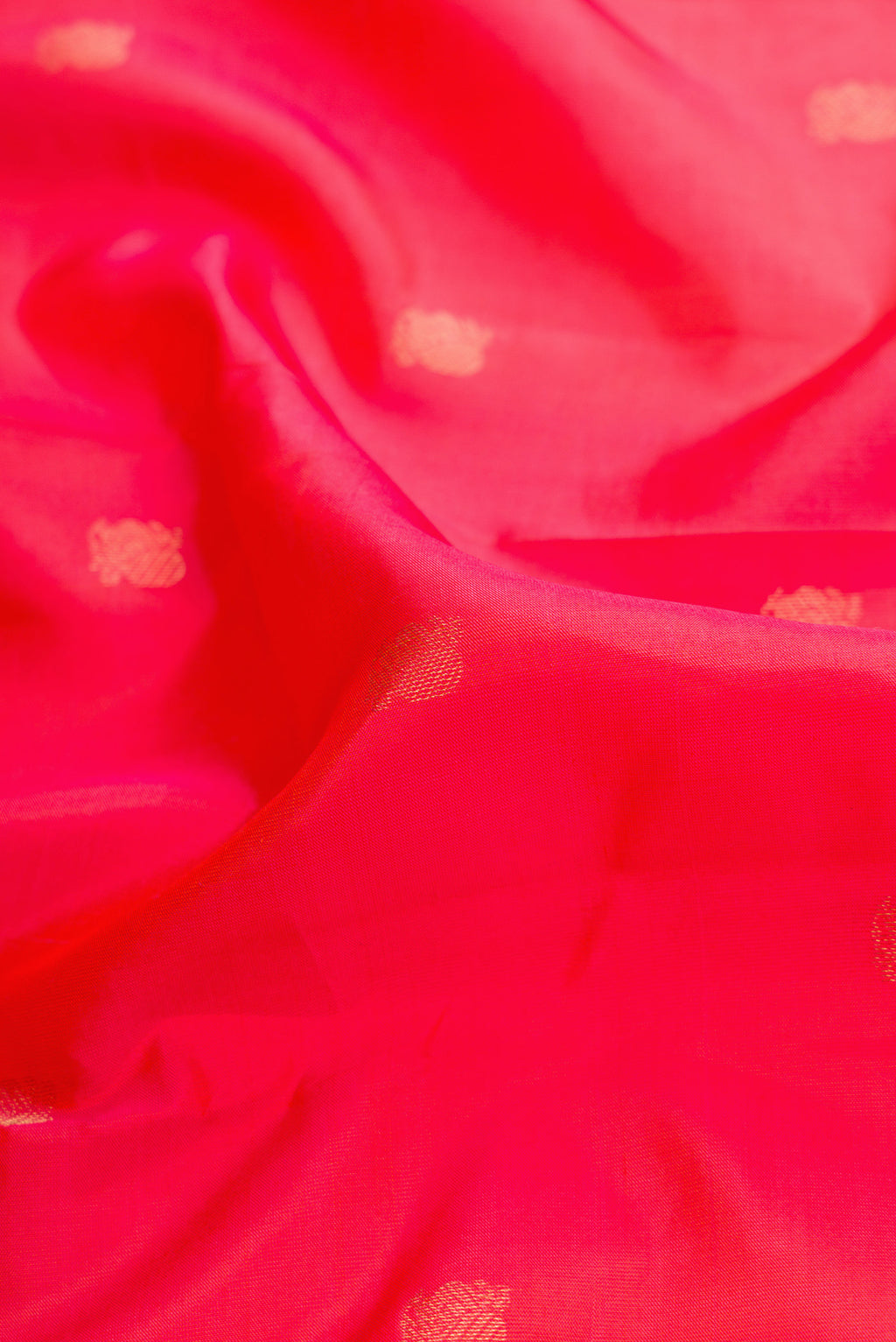 Close up of Coral Dual Tone Kanjivaram Silk Saree with Zari Butta on the body and Thin Zari Line.  displaying folds