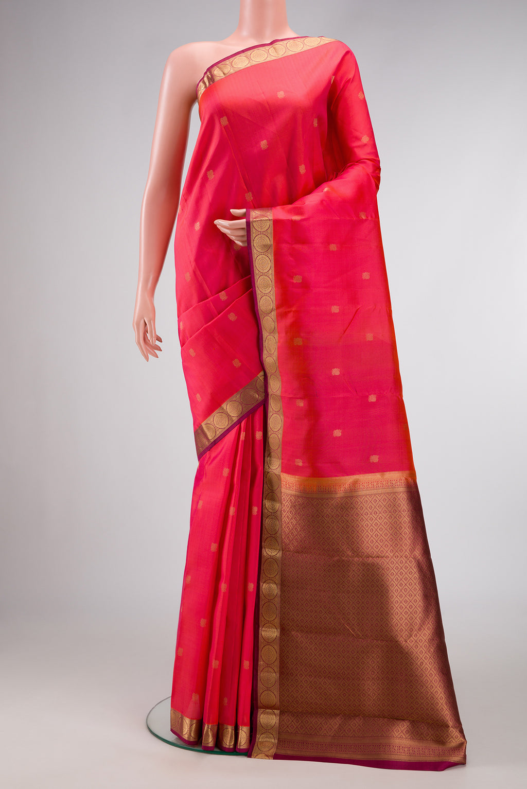 Coral Dual Tone Kanjivaram Silk Saree with Zari Butta on the body and Thin Zari Line.  displayed on a mannequin