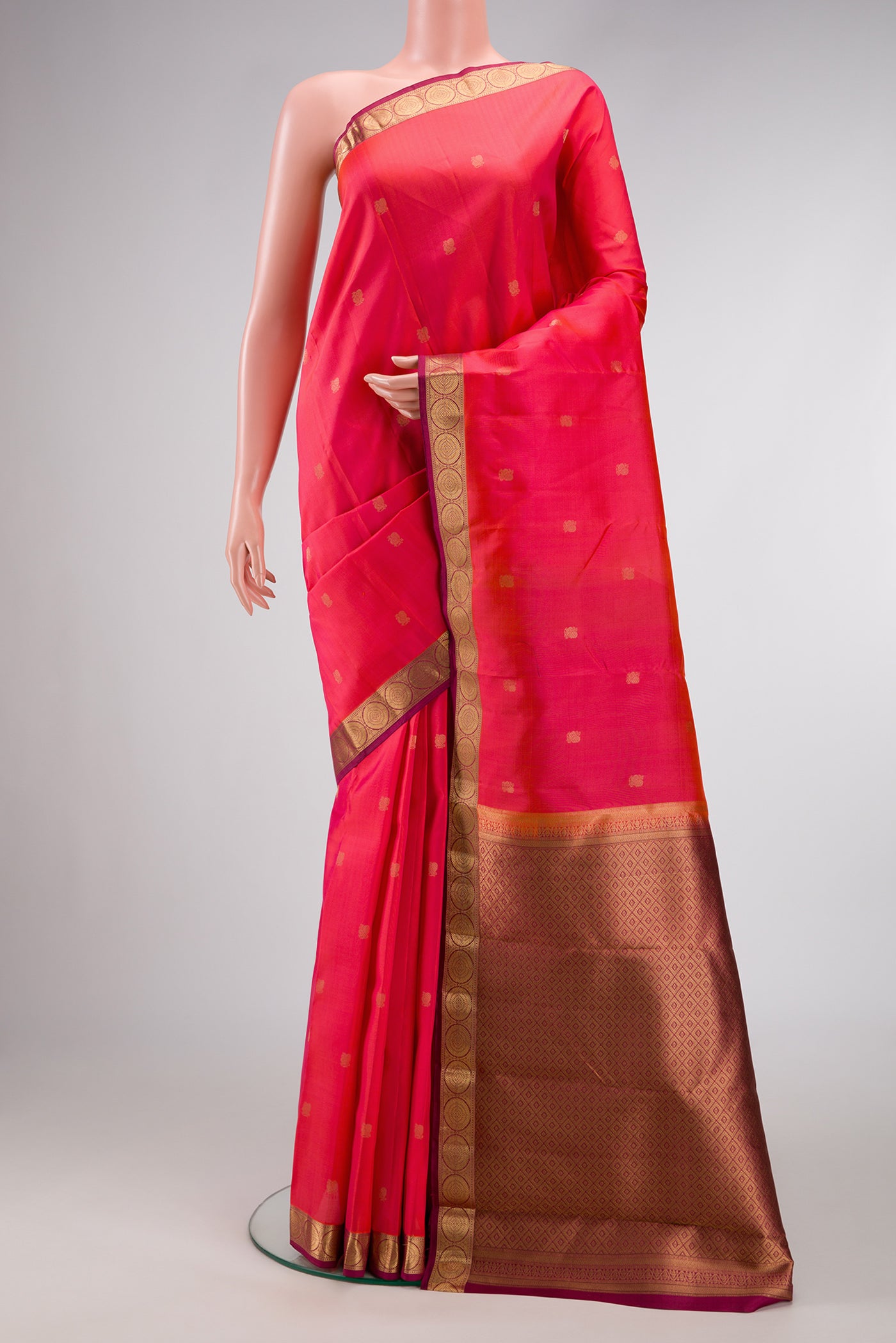 Coral Dual Tone Kanjivaram Silk Saree with Zari Butta on the body and Thin Zari Line.  displayed on a mannequin