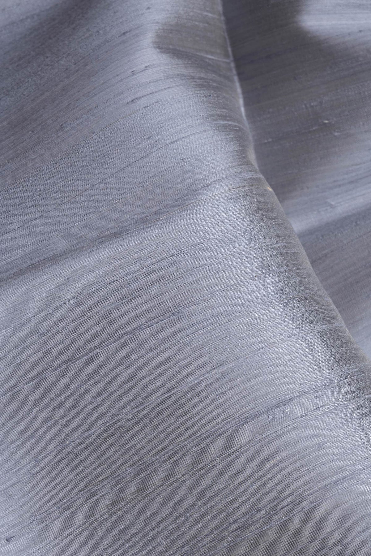 Close up of Grey Dual Tone Raw Silk Saree with Plain Body and Zari Border.  displaying folds