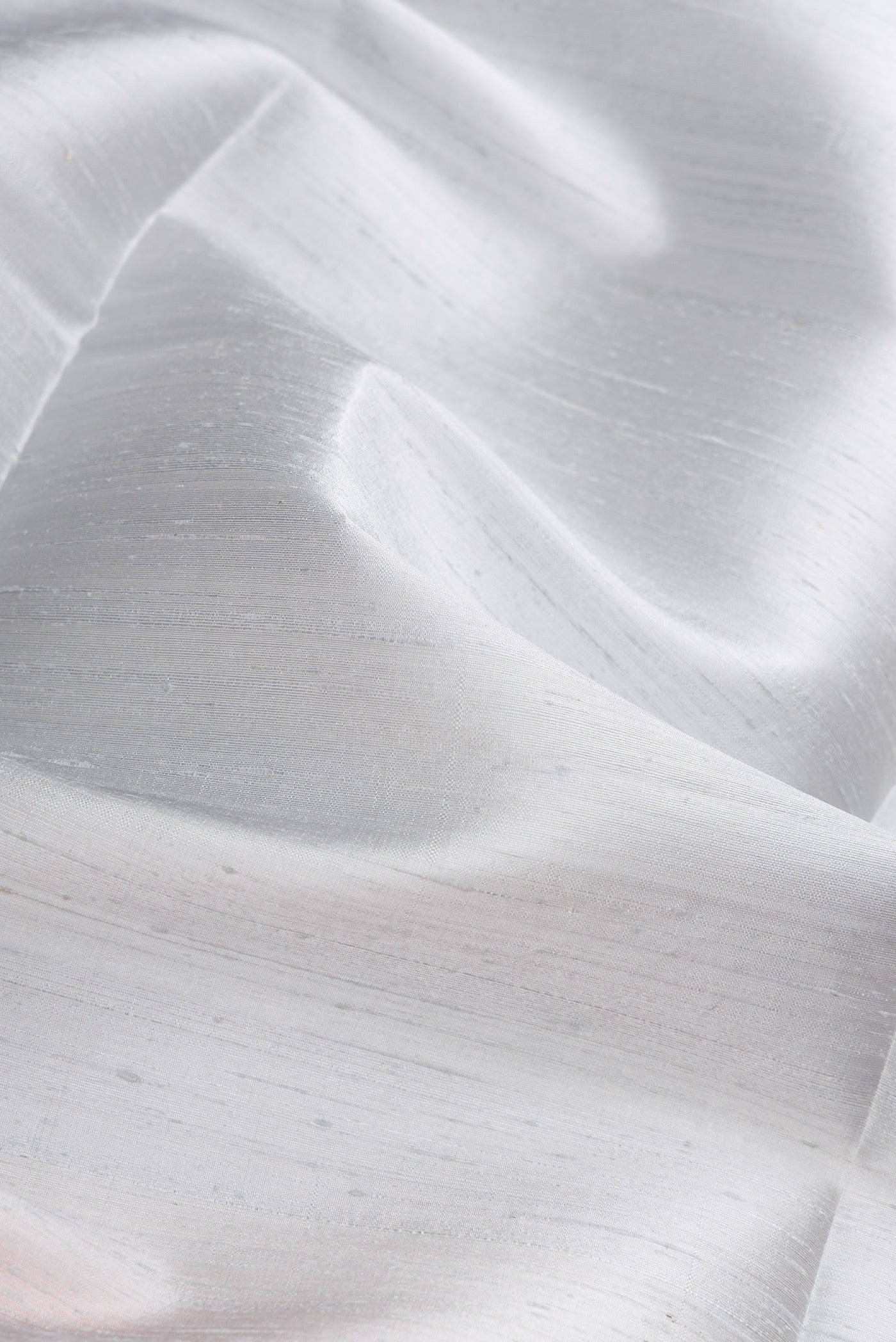 Close up of Grey Dual Tone Raw Silk Saree with Plain Body and Zari Border.  displaying folds