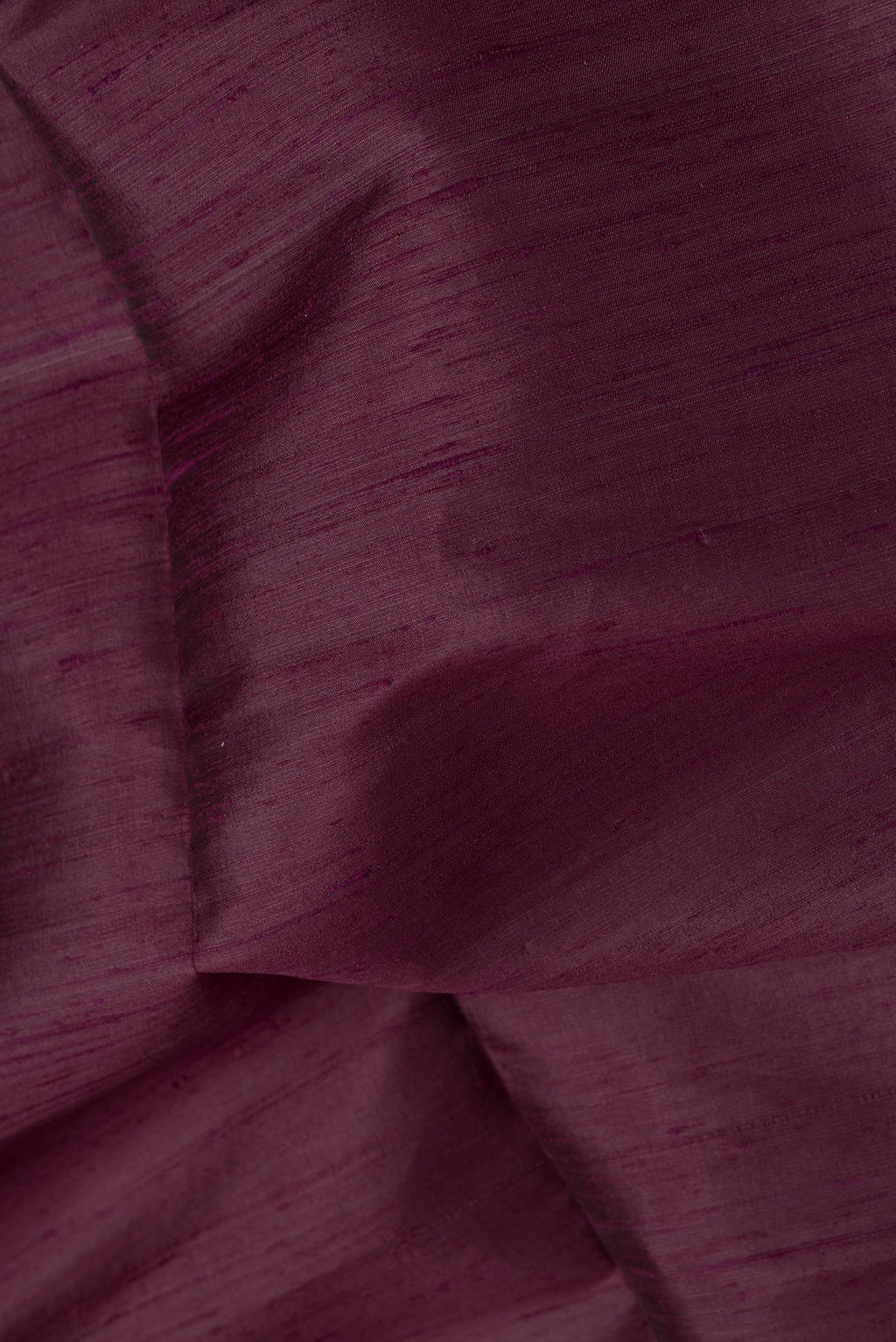 Close up of Burgundy Dual Tone Raw Silk Saree with Plain Body and Zari Border.  displaying folds